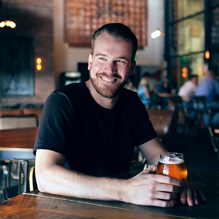 Man holds beer while smiling