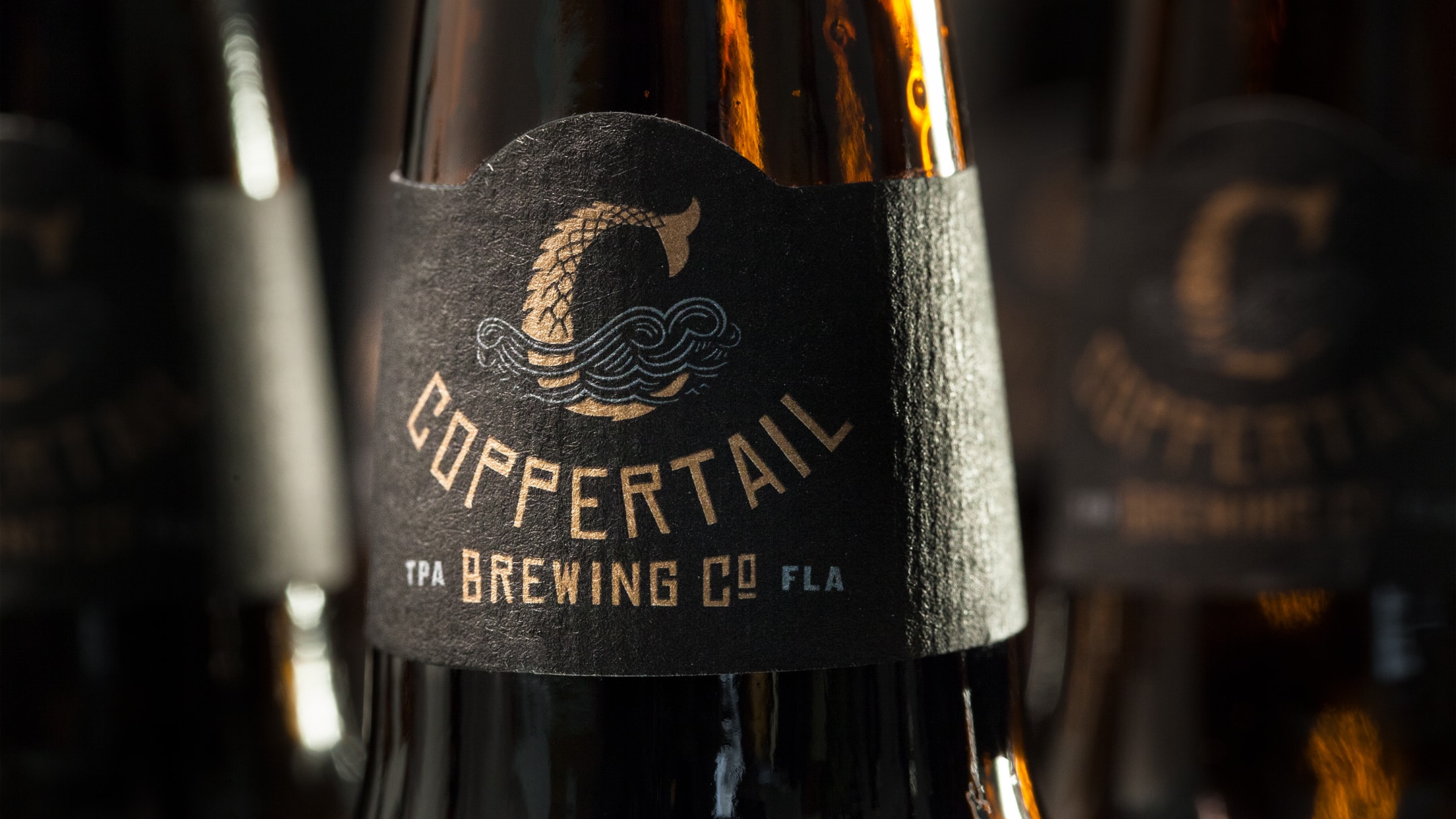 Close up of coppertail beer branding and bottle packaging design.