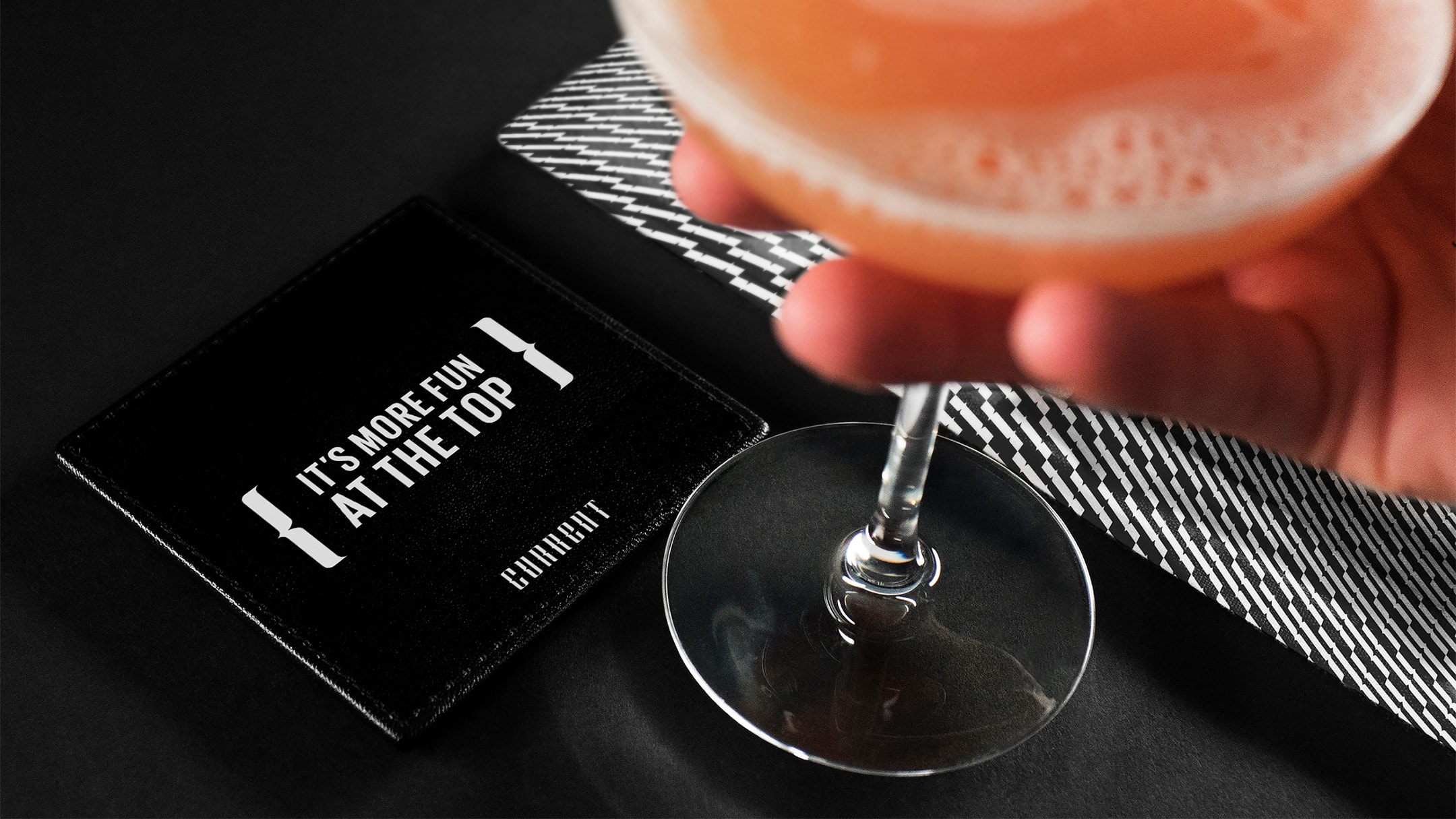 Current hotel branded coaster with a drink.