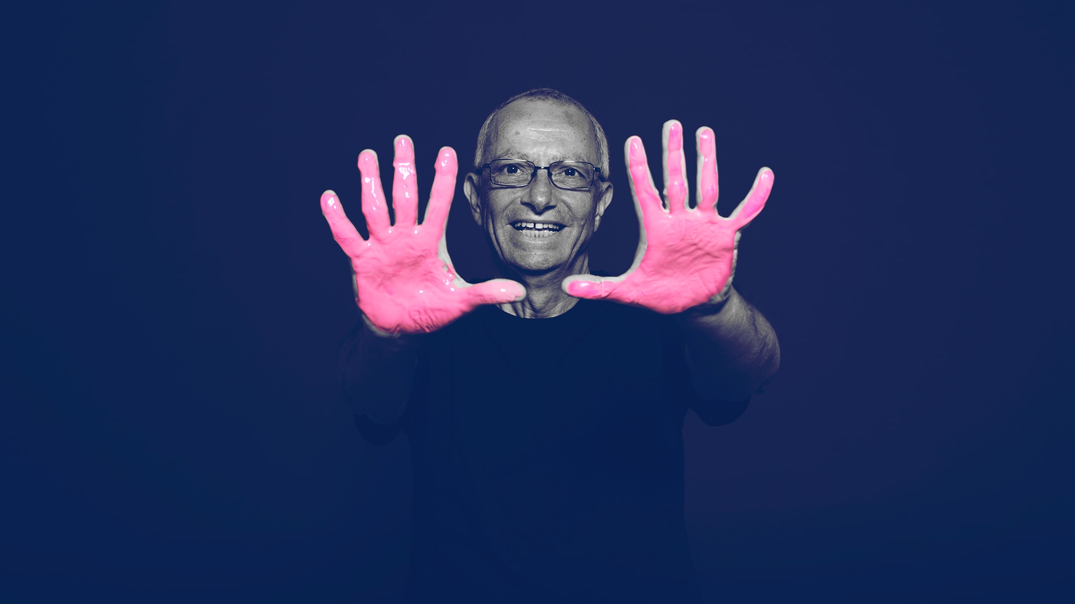 BayCare survivor posing for the in our hands campaign with pink paint on his hands
