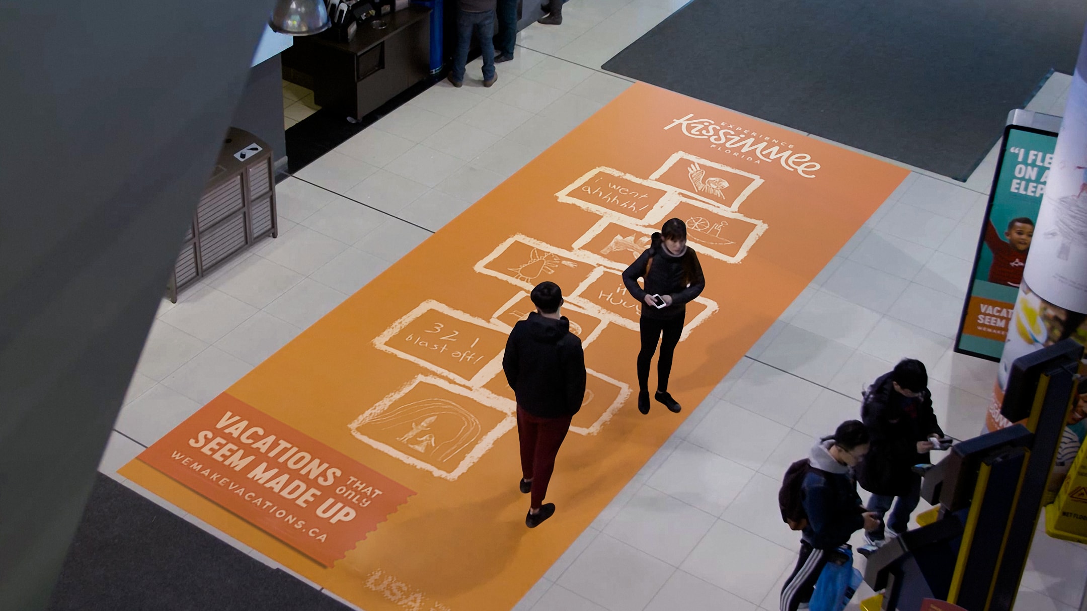 Experience Kissimmee hopscotch ad on mall floor.