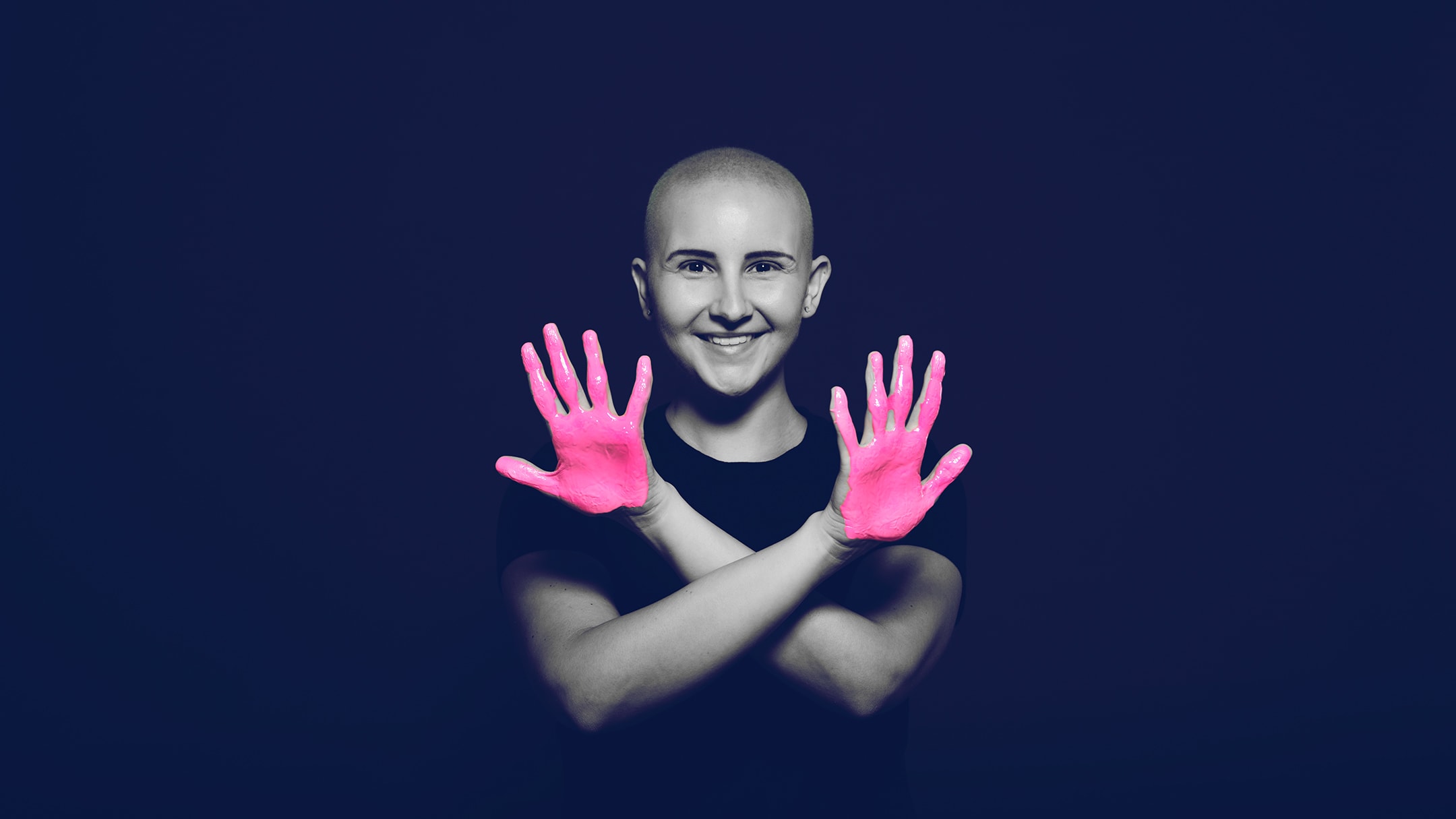 Breast cancer survivor posing for the in our hands campaign with her arms crossed over her chest, palms facing out, and pink paint on her hands. BayCare Hospital Marketing campaign
