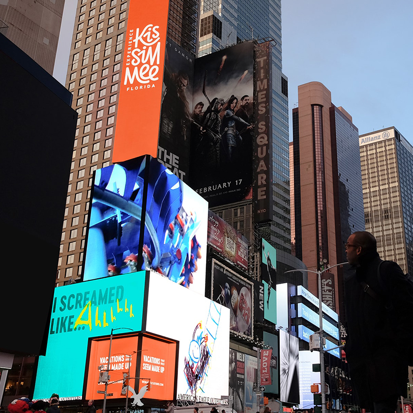 A man looking at Experience Kissimmee digital billboards in Time Square, NY.