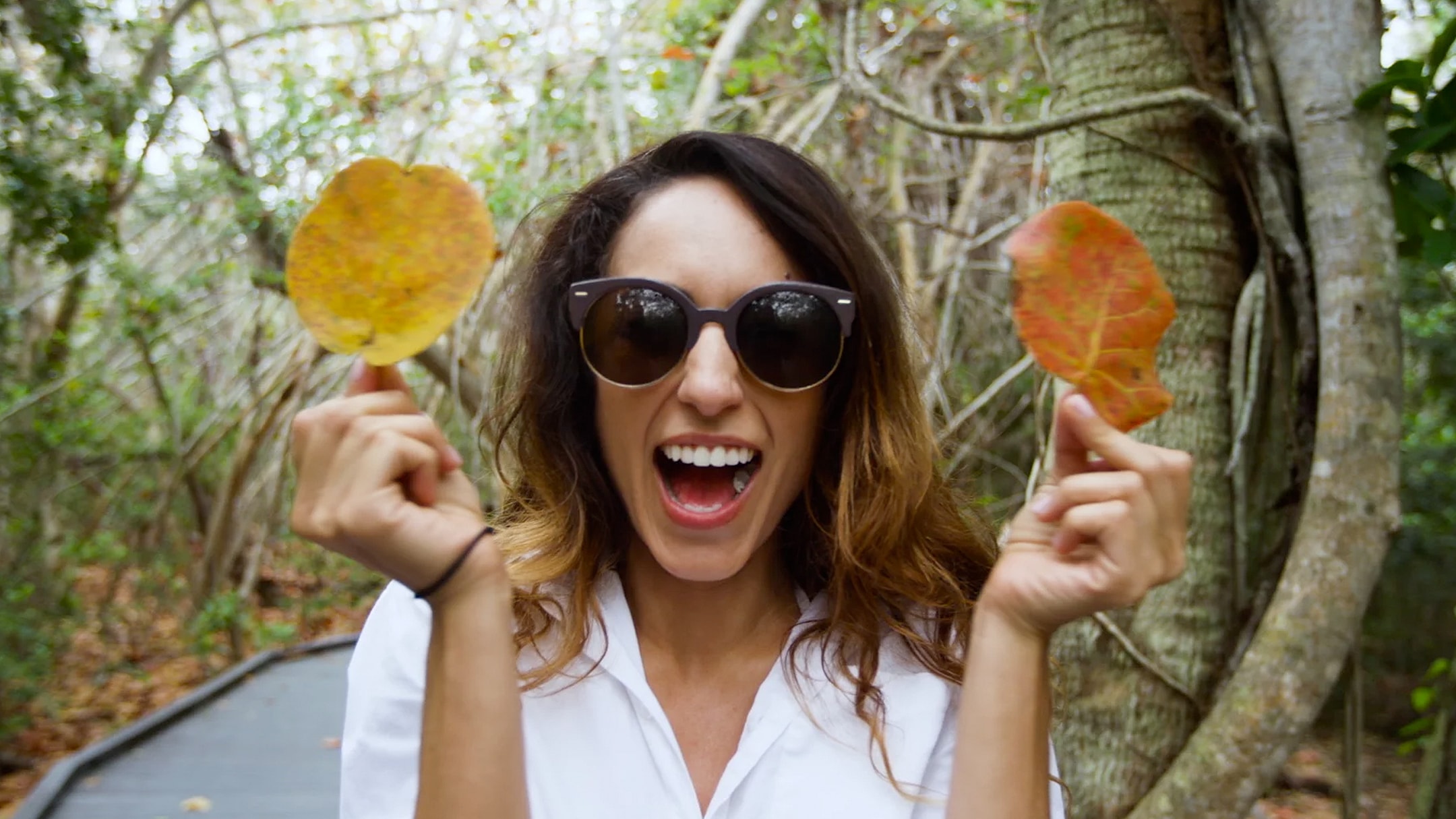 Woman screams with two leaves - a still taken from an influencer marketing video.